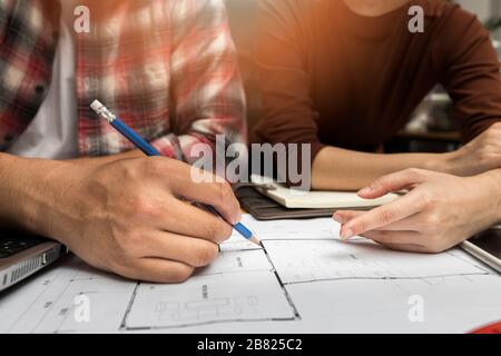 Group of two coworkers working with blueprint in office. co-working teamwork concept. Stock Photo