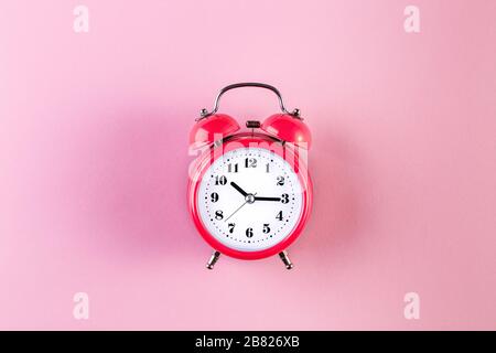 Red vintage alarm clock on light pink color background. Alarm clock with place for text. Time management concept, business planning Stock Photo