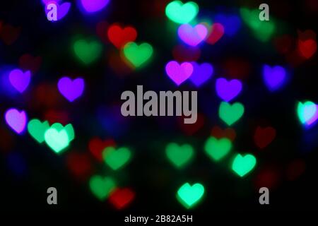 Valentines Colorful heart-shaped bokeh on black background lighting bokeh for decoration at night backdrop wallpaper blur valentine, Love Pictures bac Stock Photo