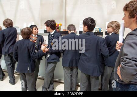 Lots of school children, school boys at the British museum, on a school trip getting snacks. Stock Photo