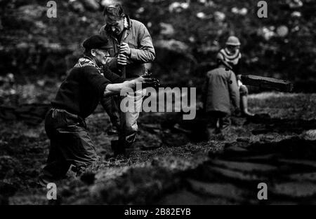 Men cutting peat on a stretch of land on the island of Lewis in the Outer Hebrides, Scotland. Peat cutting was a traditional method of gathering fuel for the winter in the sparsely-populated areas on Scotland's west coast and islands. The peat was dried and used in fires and ovens. Stock Photo