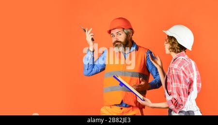 talk about interior decoration. under construction. looking at construction house plan. how new home is being built. Worker show house design. couple discussing blueprint at home. real estate deal. Stock Photo