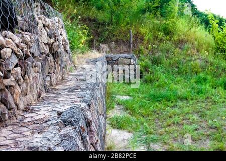 Gabion wall - stones in wire mesh used for erosion control and slope reinforcement Stock Photo