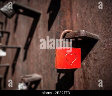 Rusty red love padlock with a heart in the middle. Stock Photo