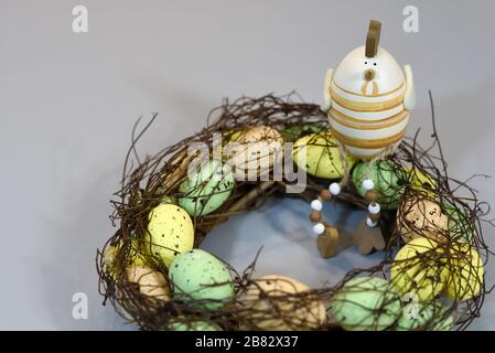 chicken figurine sitting on an Easter wreath, homemade festive interior decoration Stock Photo