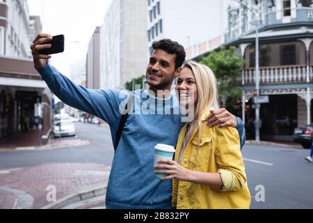 Caucasian couple on the go in the city taking selfie Stock Photo