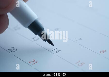 man's hand with pen marking on calendar, deadline concept  Stock Photo