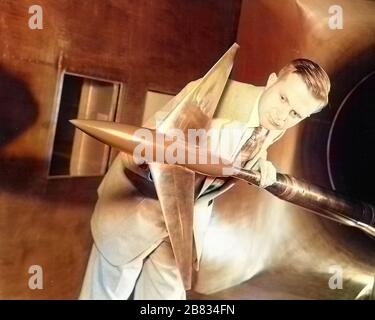 Aviation pioneer Richard Whitcomb holding an Area Ruled Aircraft test model in the Langley 8-Ft Transonic Wind Tunnel, Langley Research Center, Hampton, Virginia, April 20, 1955. Image courtesy National Aeronautics and Space Administration (NASA). Note: Image has been digitally colorized using a modern process. Colors may not be period-accurate. () Stock Photo