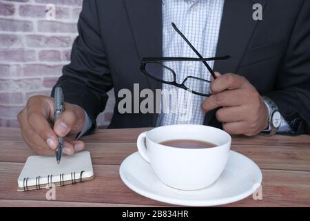 businessman writing on notepad on table at office table  Stock Photo