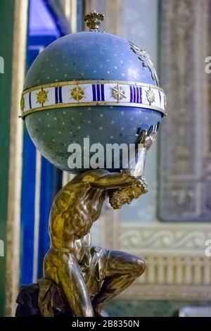 Royal Palace, Napoli, Italy, september 2017. This is a relatively small but interesting statue. It represents Atlas holding the heavy sky sphere inspi Stock Photo