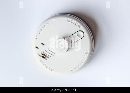 White plastic ceiling-mounted smoke and heat detector used to activate warning systems in residential buildings Stock Photo