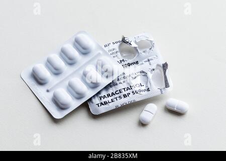 Paracetamol tablets in a blister pack, two tablets removed, against a plain background Stock Photo