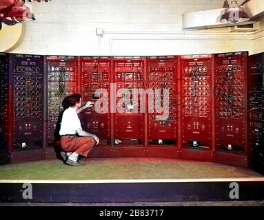 NASA engineer operating Analog Computing Machine in the Fuel Systems Building at the Lewis Flight Propulsion Laboratory, Cleveland, Ohio, September 28, 1949. Image courtesy National Aeronautics and Space Administration (NASA). Note: Image has been digitally colorized using a modern process. Colors may not be period-accurate. () Stock Photo