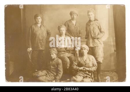 Original WW1 era real photographic postcard of German lady riveters - munitions or dock workers holding rivets, 1914-1918, Germany Stock Photo
