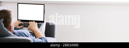 Cropped Image Of Young Man Using Laptop At Home Stock Photo