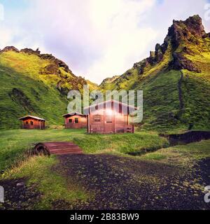 three wooden cabins at Thakgil campsite in Iceland in early morning at sunrise Stock Photo