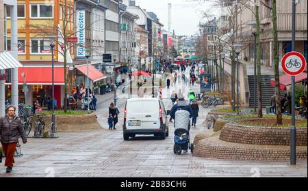 View of the city centre busy with unidentified people shopping at the Wilhelminenstrasse on a cloudy day in winter. Darmstadt, Germany. Stock Photo