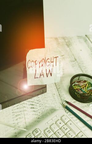 Writing note showing Copyright Law. Business concept for body of law that governs the original works of authorship Note paper taped to black computer Stock Photo