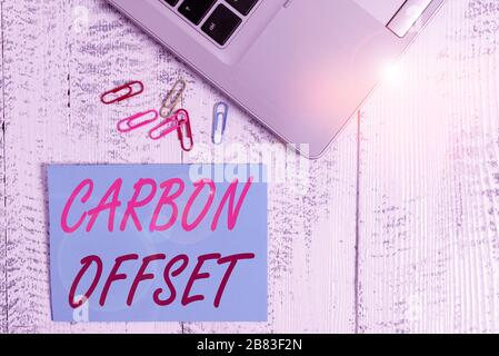 Writing note showing Carbon Offset. Business concept for Reduction in emissions of carbon dioxide or other gases Trendy metallic laptop blank sticky n Stock Photo