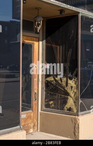 Cracked glass window pane by shop door looking like rioters have tried to enter the store Stock Photo