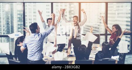 Business team celebrating a triumph with arms up, , celebrating the performance of new product of colleague working together Stock Photo