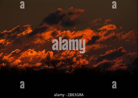 Dramatic dawn red-colored clouds at sun rise Stock Photo