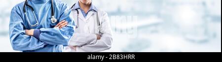 Young couple of surgeon and doctor in front of blurred the interior of the operating room or clinic Stock Photo