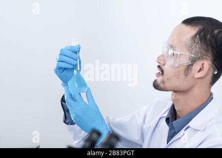 Scientists are studying laboratory chemicals, blue chemicals in tube Stock Photo