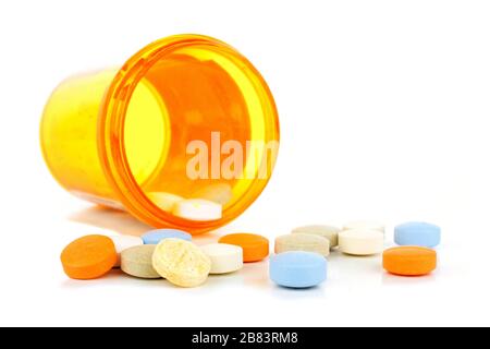 Pill bottle with spilling medicine tablets over white Stock Photo