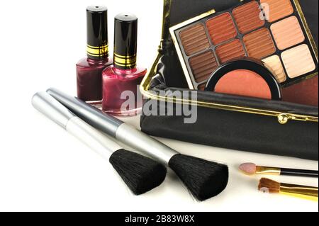 Makeup bag close up with assorted cosmetics on a white background Stock Photo