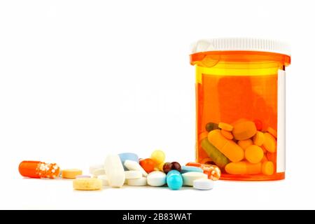 Pill bottle with pile of varied medicine over a white background Stock Photo