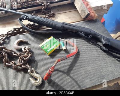 Pump shotgun on a table with chains and bullets Stock Photo