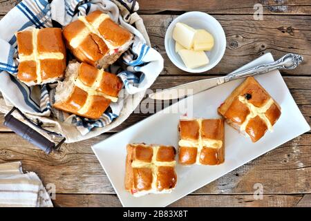 Easter Hot Cross Buns, overhead scene with basket and plate on rustic wood background Stock Photo