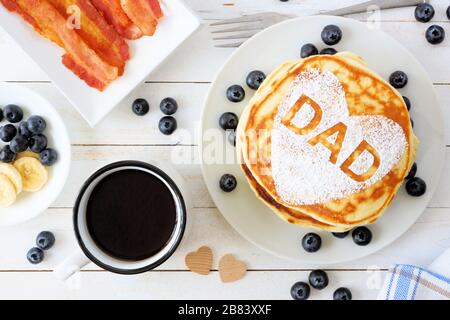 Fathers Day pancakes with heart shape and DAD letters. Fathers Day breakfast concept. Above view table scene on a white wood background. Stock Photo