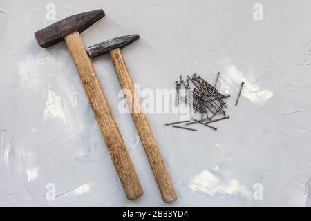 Two hammers and old rusty nails on gray background, carpentry concept, copy space Stock Photo