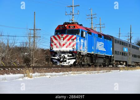 Geneva, Illinois, USA. A Metra locomotive leading a train bringing commuters home from Chicago on a sunny winter afternoon.