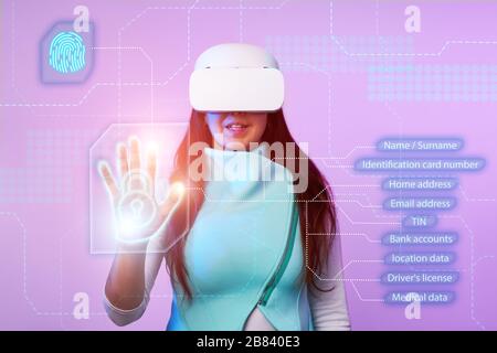 Woman is using vr headset to access for personal data. Concept of using future technology for cybersecurity, protection personal data. Stock Photo