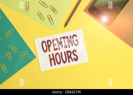 Handwriting text writing Opening Hours. Conceptual photo the time during which a business is open for customers Paper sheets pencil clips smartphone s Stock Photo