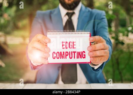 Handwriting text Edge Computing. Conceptual photo practice of processing data near the edge of your network Man holds empty paper with copy space in f Stock Photo