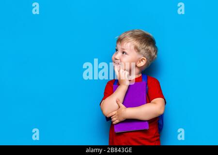 Back to school Portrait of happy surprised kid in glasses isolated on blue background with copy space. new school knowledges Stock Photo