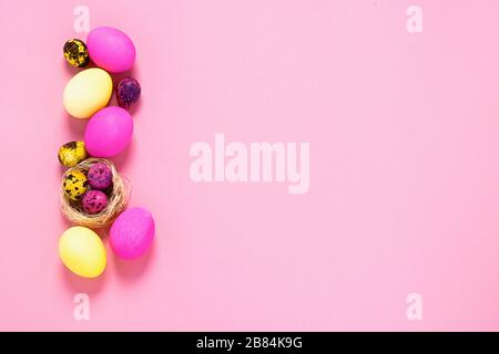 Happy easter concept. Colored eggs lie in a row on a pink background. Copy space flat layout. Banner with place for text advertising. Stock Photo