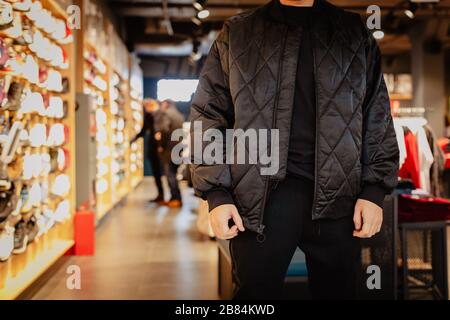 Person in warm jacket in shop near light windows Stock Photo