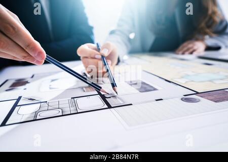 Close-up Of Two Architects Hands Working On Blueprint Stock Photo