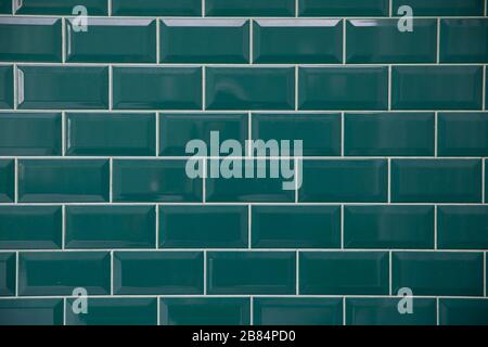 Emerald bricks. Brick type tile with white seams. Bricks are laid out in even repeating rows. Stock Photo