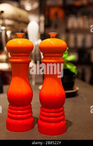 salt and pepper mill in orange color on table Stock Photo