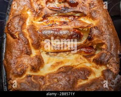 2 Top down and overhead view of a crisp and golden toad in the hole, i.e. sausages encased in batter, fresh from the oven Stock Photo