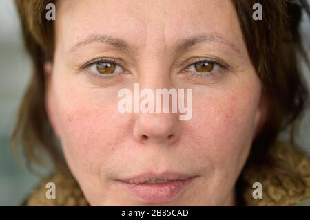 Serious middle-aged Hispanic woman looking at camera with a slight frown and pensive expression in a close up cropped head shot Stock Photo