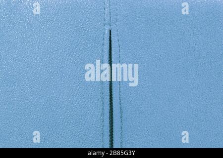 Background from blue suede close up, zipper in the middle, full frame Stock Photo