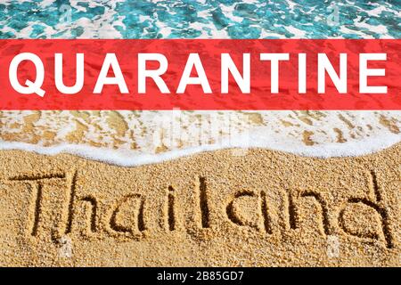 Words THAILAND and QUARANTINE on beach sand and blue sea wave landscape, Coronavirus pandemic, covid 19 epidemic, warning symbol, restriction sign Stock Photo