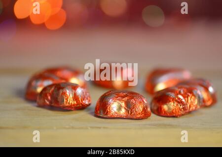 Red chocolate hearts wrapped in red foil for Valentine's Day. Stack of chocolate heart Stock Photo